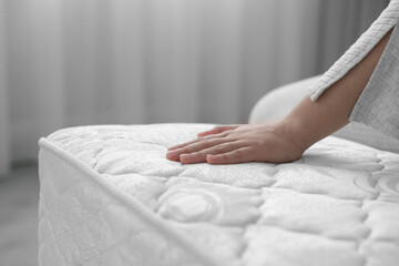 Woman touching soft white mattress indoors, closeup - obrazy, fototapety, plakaty