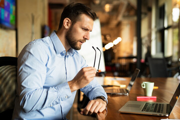 Young businessman using laptop in his office. Handsome man working on the project