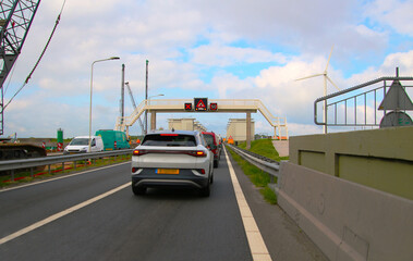 Obraz na płótnie Canvas Traffic jam on causeway over major dam due to open floodgates (Afsluitdijk, Netherlands)