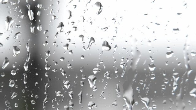 Raindrops run down the glass of the window. Transparent splashes of water - bad weather, autumn, spring, cloudy. Slow Motion