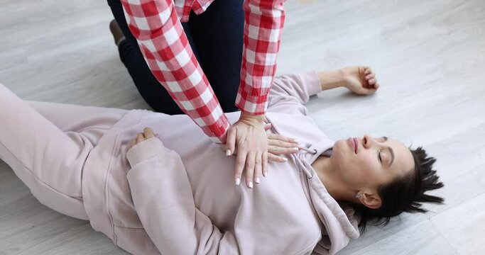Person trying to save woman from heart attack closeup