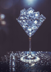 ice cubes are not a dark table. martini glasses on dark background. martini ice on a dark table. cocktail ingredients. crystals on black background