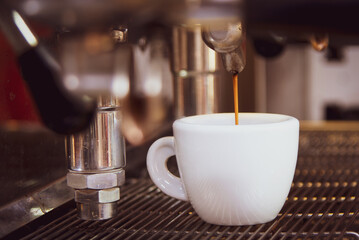 Close-up of espresso pouring from the coffee machine. Professional coffee preparation
