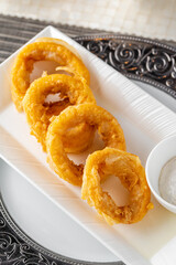 Delicious calamari on a white porcelain plate with salad and sauce