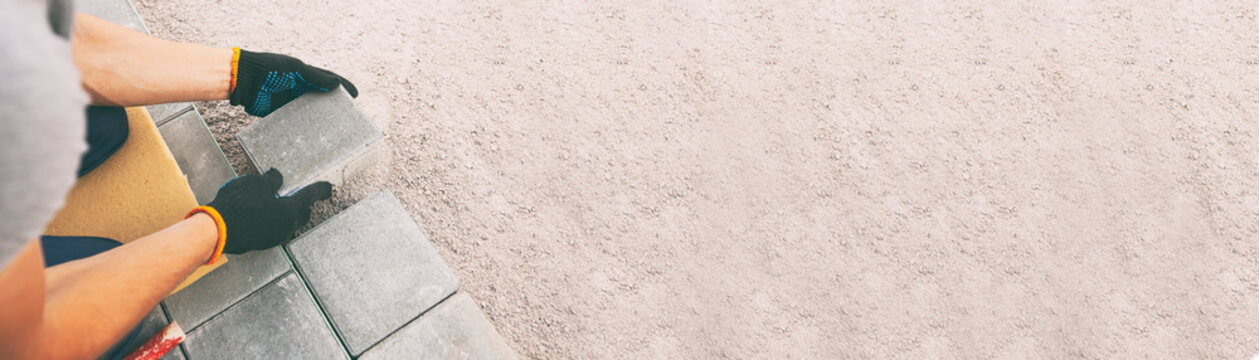 Worker lining paving slabs path