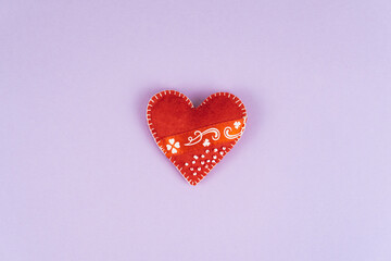 Top view Valentine's Day concept with copy space. Red textile heart on purple papper background