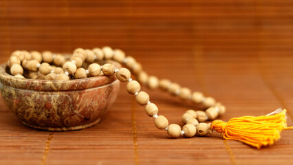 buddhist prayer beads on wooden background for meditation and mindfulness, close up. Yoga banner