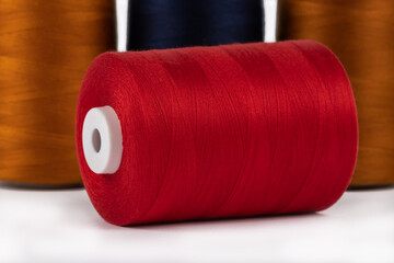 Spool of sewing thread, isolated on white background. Colored yarns used by factories in the...