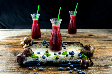 Juice with Beetroot, blueberries and mint in glass jar with fruits and vegetables on the wooden...