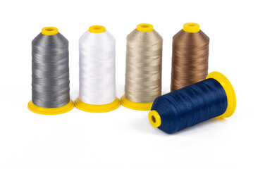 Spool of sewing thread, isolated on white background. Colored yarns used by factories in the...