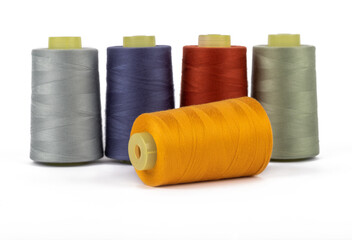 Spool of sewing thread, isolated on white background. Colored yarns used by factories in the clothing industry. Threads wound on the spool. Colored reels