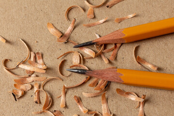 Two professional sharpened wooden pencils on a cardboard sheet