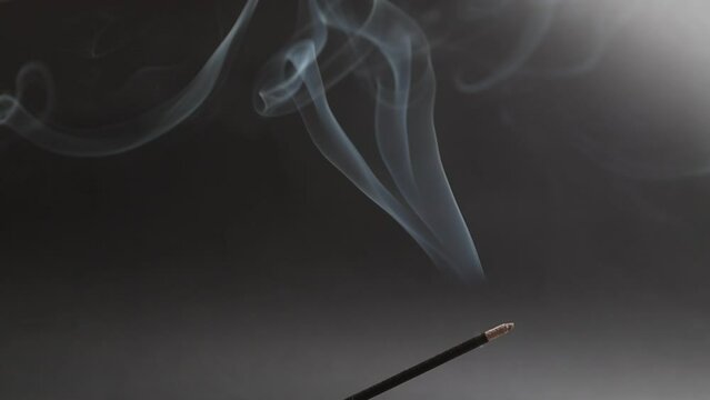 Smoke from aroma incense sticks on a black background.