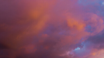 Teintes rougeâtres sous des cumulus, pendant le crépuscule