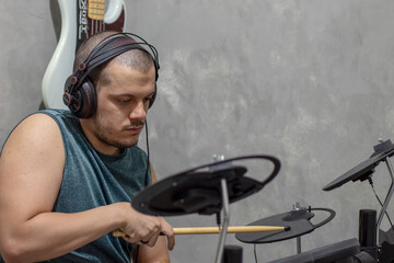 Fototapeta na wymiar Man playing electronic drums in house
