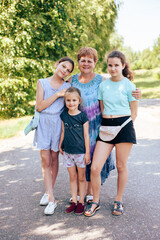 Grandmother and her three granddaughters in the park in summer