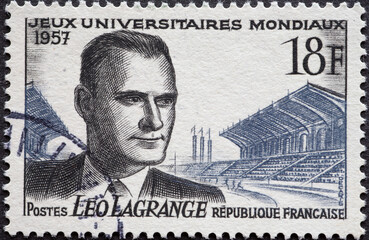 France - circa 1957: a postage stamp from France, showing a portrait of Leo Lagrange in front of a...
