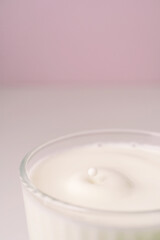 Milk drips into a transparent faceted glass.