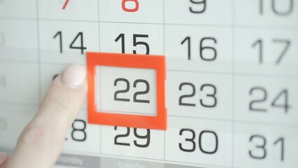 Close-up of a woman's finger moves the date pointer on the calendar