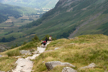 Fototapeta na wymiar A distant group of you male adults returning from stag party on the mountains in the UK.