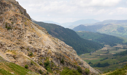 Distant mountain views of Blencathra, Bleaberry Fell, Grange Fell and Seatoller from the rocky crags of below Base Brown in the English Lake District, UK.