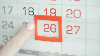 Close-up of a woman's finger moves the date pointer on the calendar