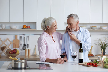 Fototapeta na wymiar Couple drinking wine and enjoying at kitchen