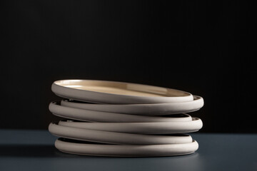 tableware, kitchen utensil and dishes concept - close up of ceramic plates on black table