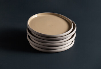 tableware, kitchen utensil and dishes concept - close up of ceramic plates on black table