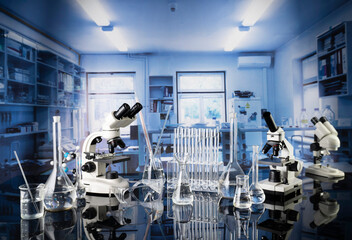 Laboratory investigations concerning test and medicine against covid. Microscope, glass tubes and beakers in the laboratory.