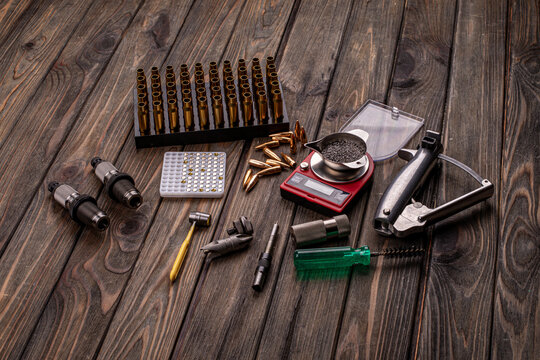 Reloading cartridges, accessories for reloading on a wooden background, preparation for reloading, soft focus