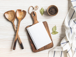Minimal white kitchen background with blank notebook for text, cutting board, cotton napkin and various spices