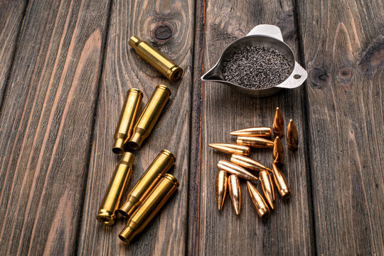 Cartridge reloading, cartridge cases, bullets and a bowl of gunpowder for reloading rifled cartridges, preparation for reloading, soft focus