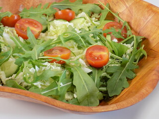 Salad on a plate of Chinese cabbage, arugula, cucumbers and tomatoes