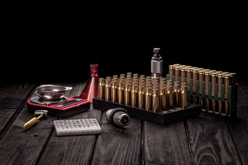 Reloading, ammo reloading accessories on black background, soft focus