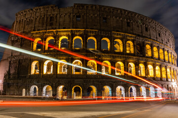 Cars light trails near the Coloseum,    Rome, Italy. Also Known As Flavian Amphitheatre In Evening Or Night Time. Famous World Landmark