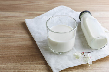 Milk bottle and glass of milk on wooden table