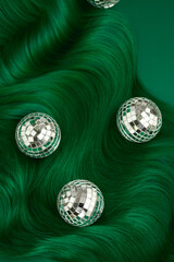 Unusual bright green natural hair colored with pigments. Beauty salon background for stories. .Small disco balls decoration like a Christmas tree