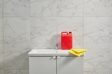 Cleaning kits on the cabinet sink in the bath room, yellow cloth, close up.