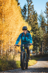 Recreational cyclist rides through the Vuokatti arena in beautiful autumn weather and at sunset. Exploring the area on fat bikes. Finnish landscape