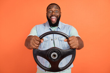 Photo of excited african guy dressed jeans waistcoat riding auto open mouth isolated orange color background