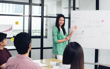 Asian beautiful businesswoman wearing casual shirt, writing on whiteboard for presentation and...