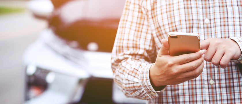 Close Up Businessman Hand Using A Mobile Smart Phone Call A Car Mechanic Ask For Help Assistance Because Car Broken Roadside. People Journey Friends Standing Wait Beside Broken Car Background.