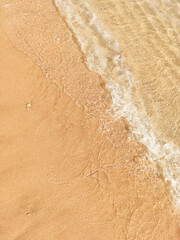 Sea wave runs over sandy beach shore. Natural trendy ecological background.