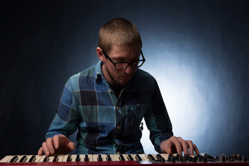 Artist playing on the keyboard synthesizer piano keys. Male musician plays a musical instrument
