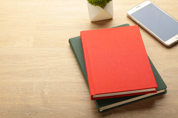 Notebook with smartphone and on beige wooden background.