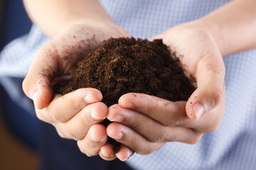 Woman holding pile of arable soil