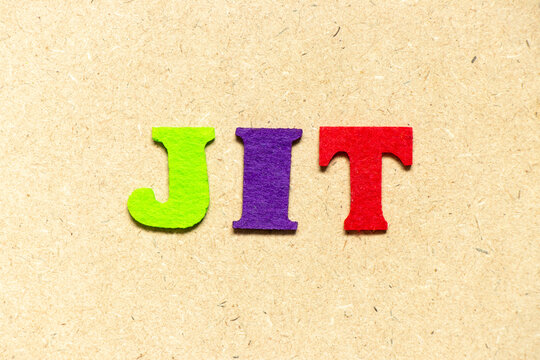 Color cloth alphabet letter in word JIT (abbreviation of just in time) on wood background