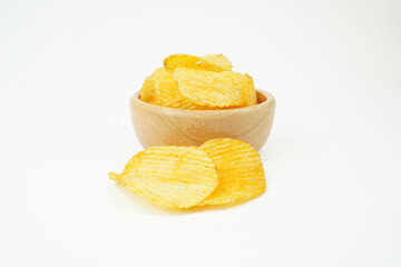 Naklejka na ściany i meble Potato chips in a wooden cup on a white background.