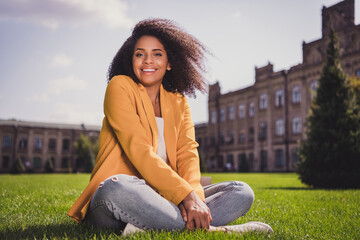Portrait of adorable attractive cheerful carefree girl traveler tourist sitting on grass enjoying life good weather outdoors